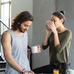 A couple enjoying a cozy breakfast with coffee and juice in their modern home kitchen.